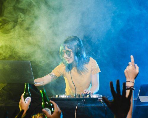 low-angle-smiley-female-dj-mixing-console